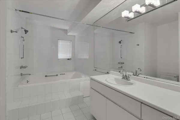 a bathroom with a sink a tub and a mirror