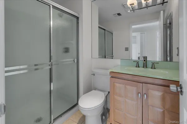 a bathroom with a granite countertop sink toilet and shower