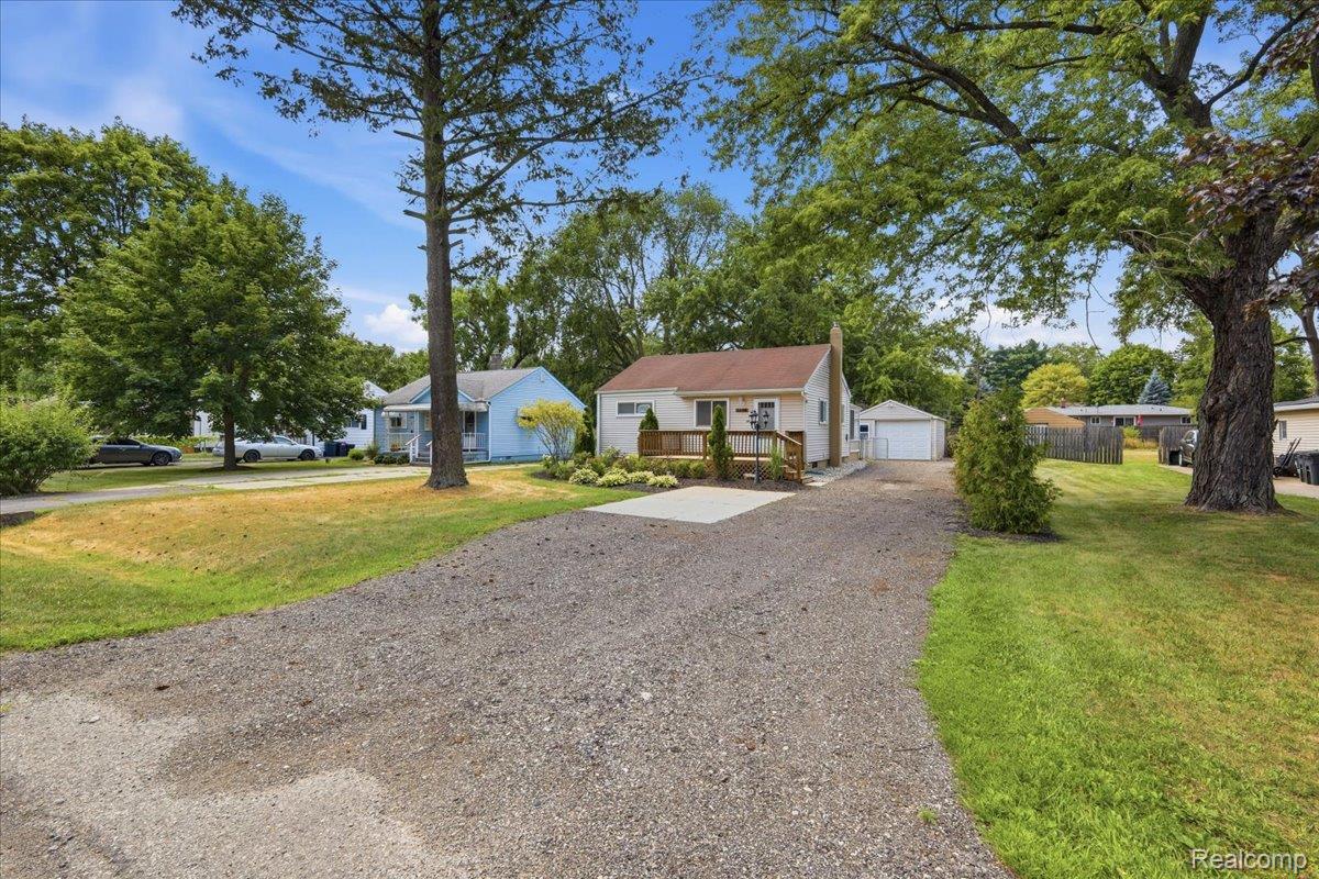 5307 Drayton Road Clarkston, MI 48346 - Photo 5 of 46 Ranch-style residence featuring a wooden deck, established landscaping, and a gravel driveway