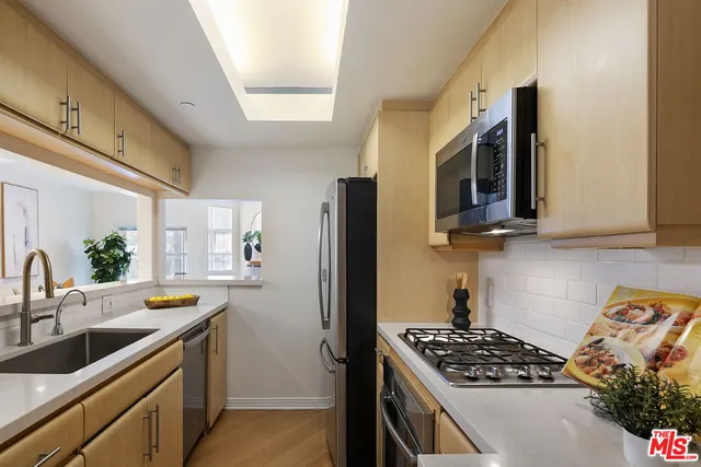 a kitchen with stainless steel appliances a sink stove and refrigerator