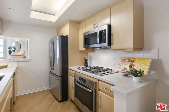 a living room with furniture a potted plant and a view of kitchen