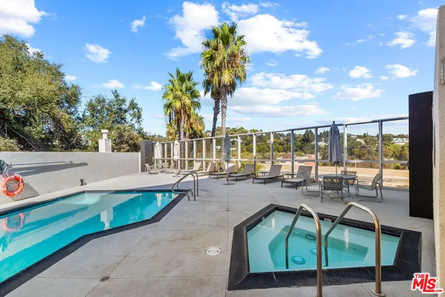 a view of a white house with a large tree