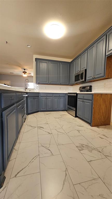611 Gladness Rhome, TX 76078 - Photo 18 of 40 a kitchen with stainless steel appliances granite countertop a stove a sink and a refrigerator