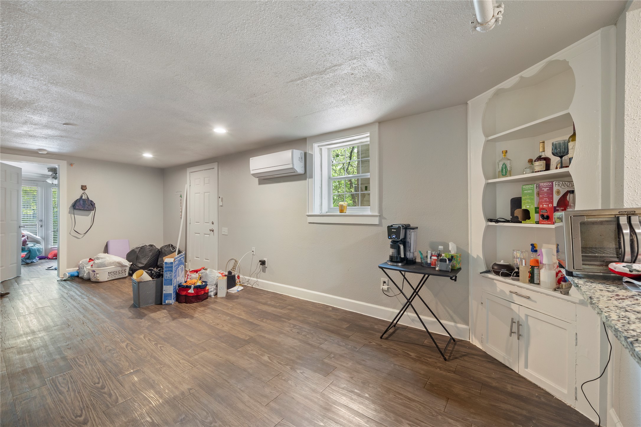 201 West 31st Street, Unit E Austin, TX 78705 - Photo 8 of 16 A versatile open space with built-in shelving, durable flooring, and ample natural light.