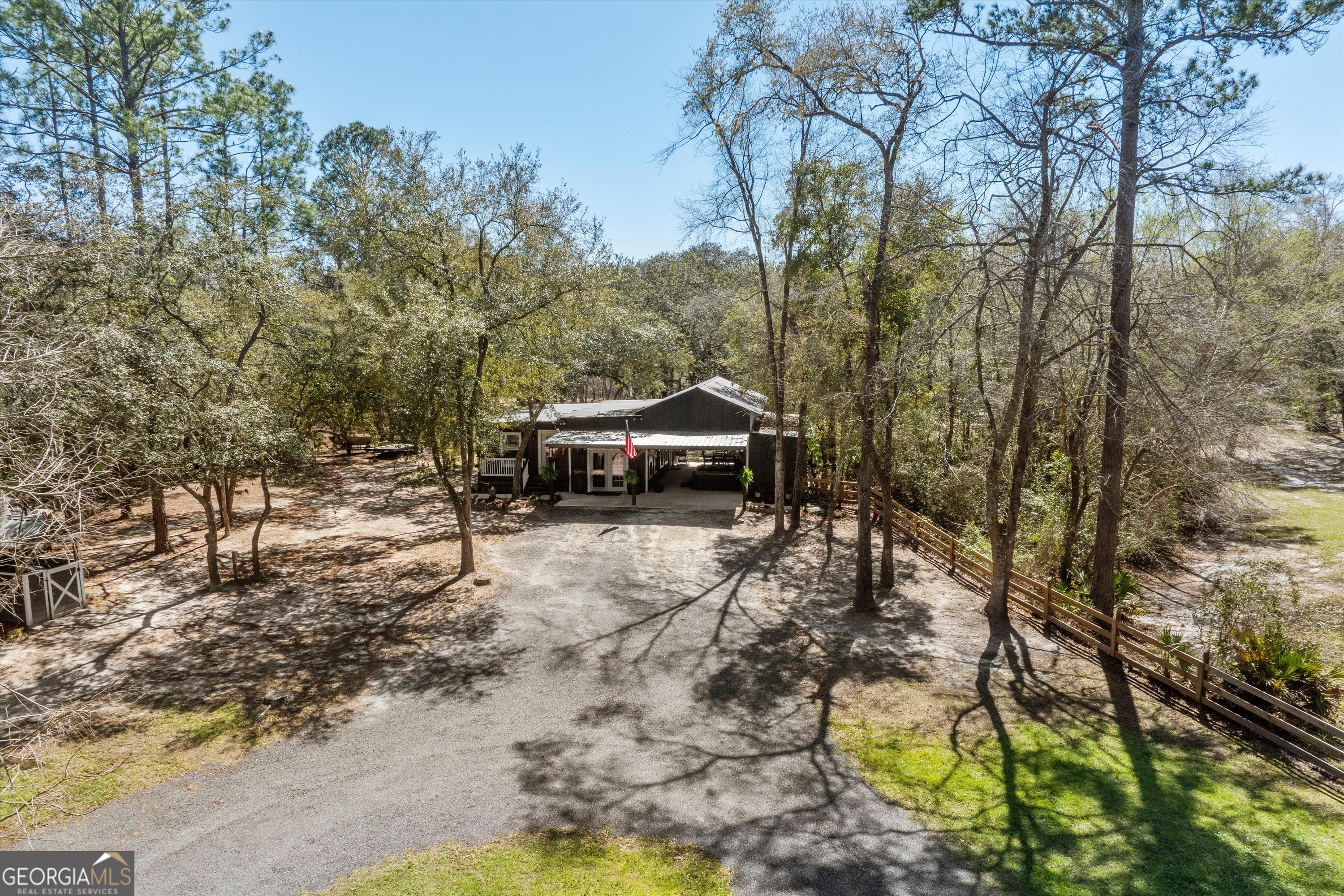 126 Flicker Lane St. George, GA 31562 - Photo 33 of 35 a backyard of a house with trees and outdoor seating