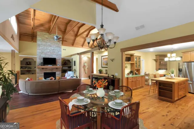 an open kitchen with dining table and wooden floor