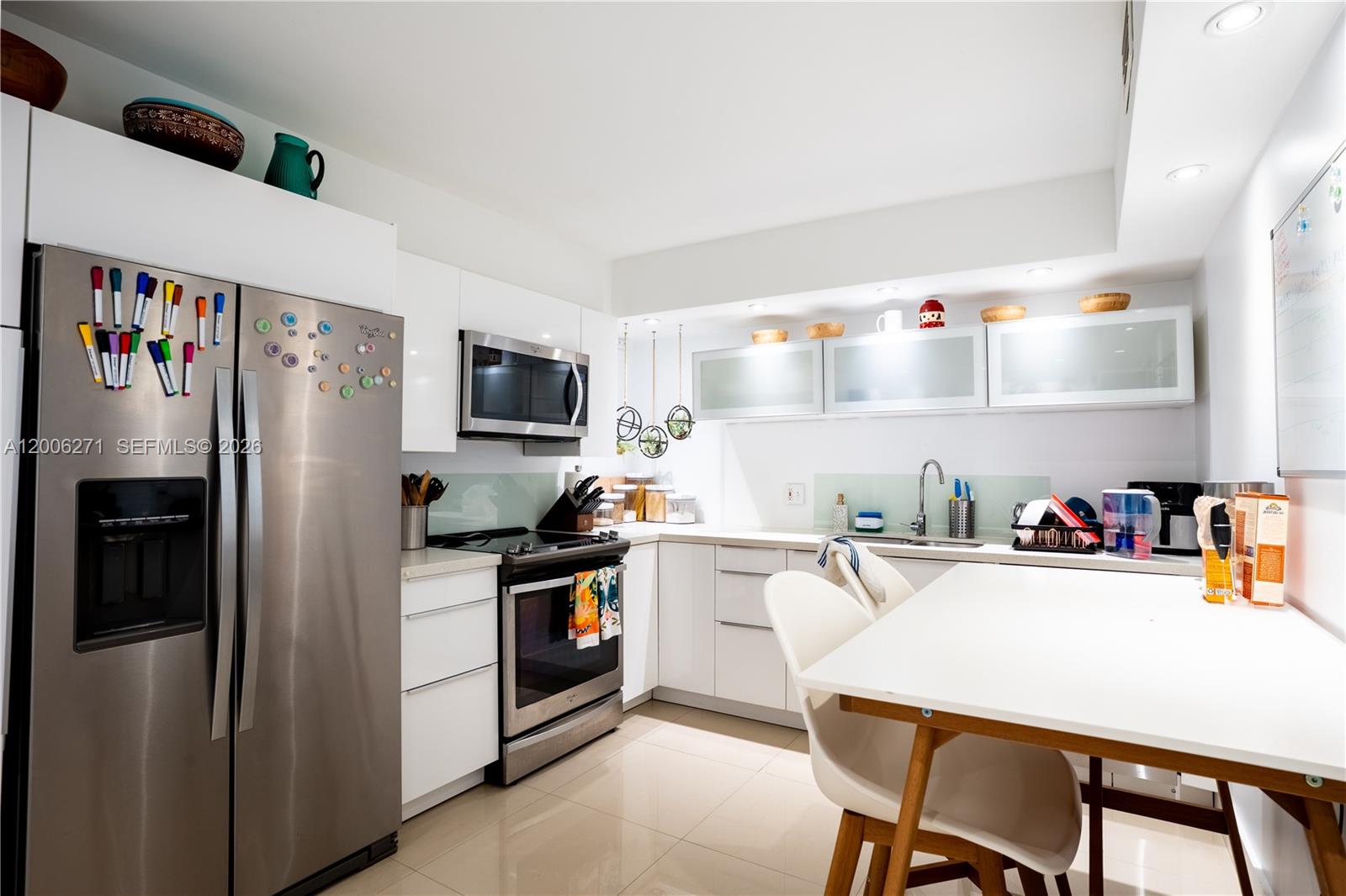 a kitchen with a refrigerator a stove and a dining table