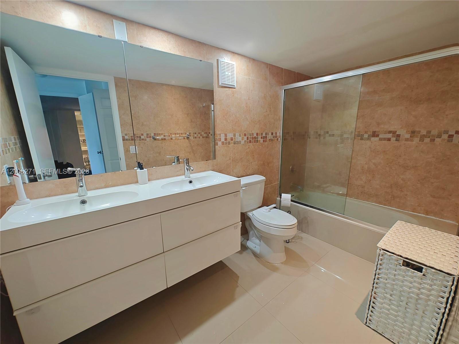 16300 Golf Club Road, Unit 204 Weston, FL 33326 - Photo 6 of 16 a bathroom with a double vanity sink toilet mirror and shower