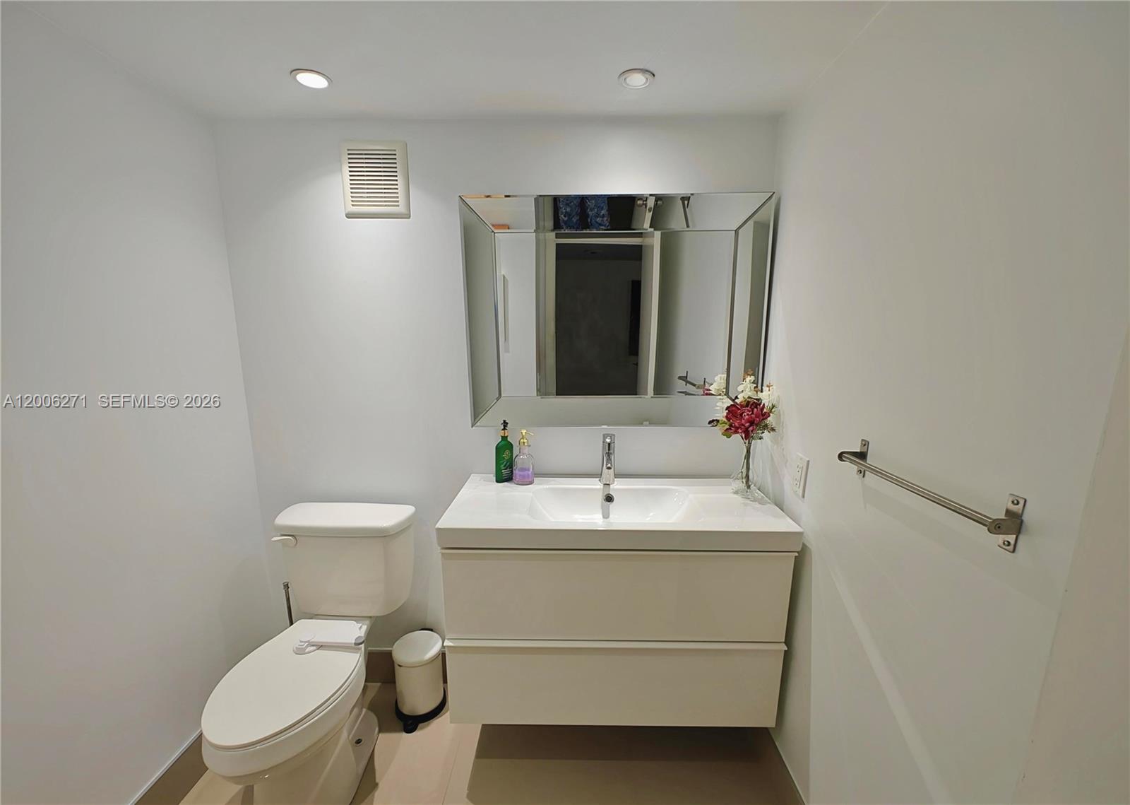 16300 Golf Club Road, Unit 204 Weston, FL 33326 - Photo 9 of 16 a bathroom with a toilet sink and mirror