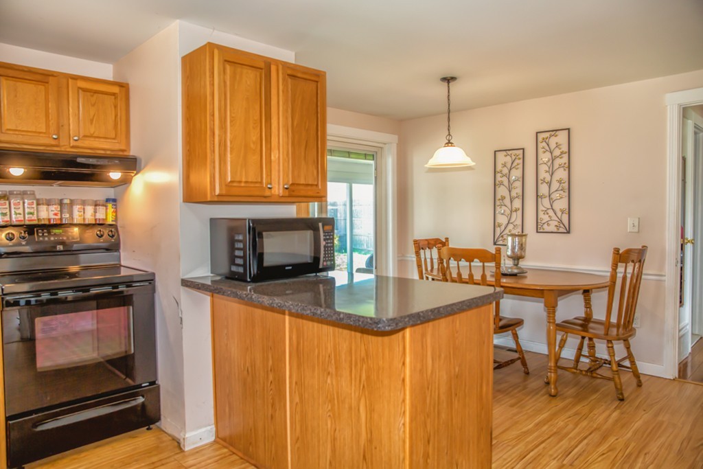 22 Fayette Street Springfield, MA 01118 - Photo 4 of 25 a kitchen with granite countertop a stove a sink a table and chairs