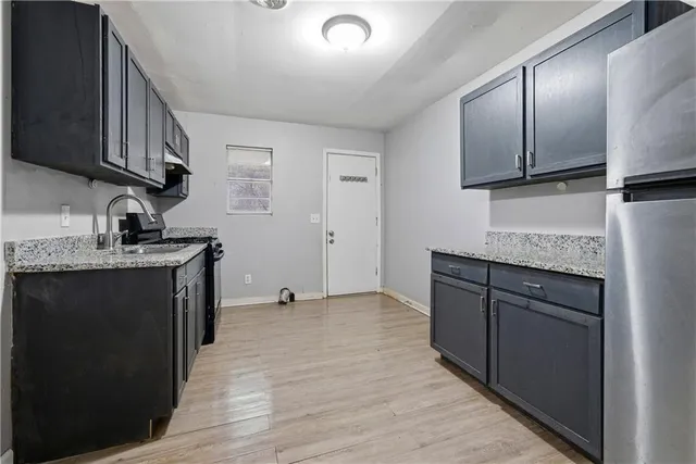 a kitchen with stainless steel appliances granite countertop a sink stove and cabinets