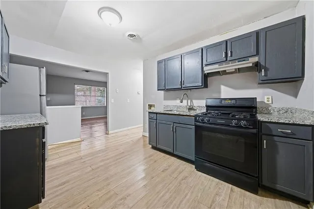 a kitchen with stainless steel appliances granite countertop a stove a sink and a refrigerator