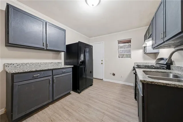 a kitchen with stainless steel appliances granite countertop a refrigerator stove and sink