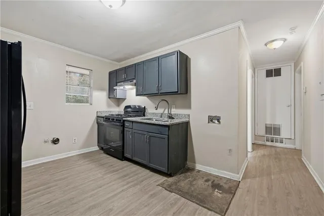 a kitchen with granite countertop a refrigerator and a sink