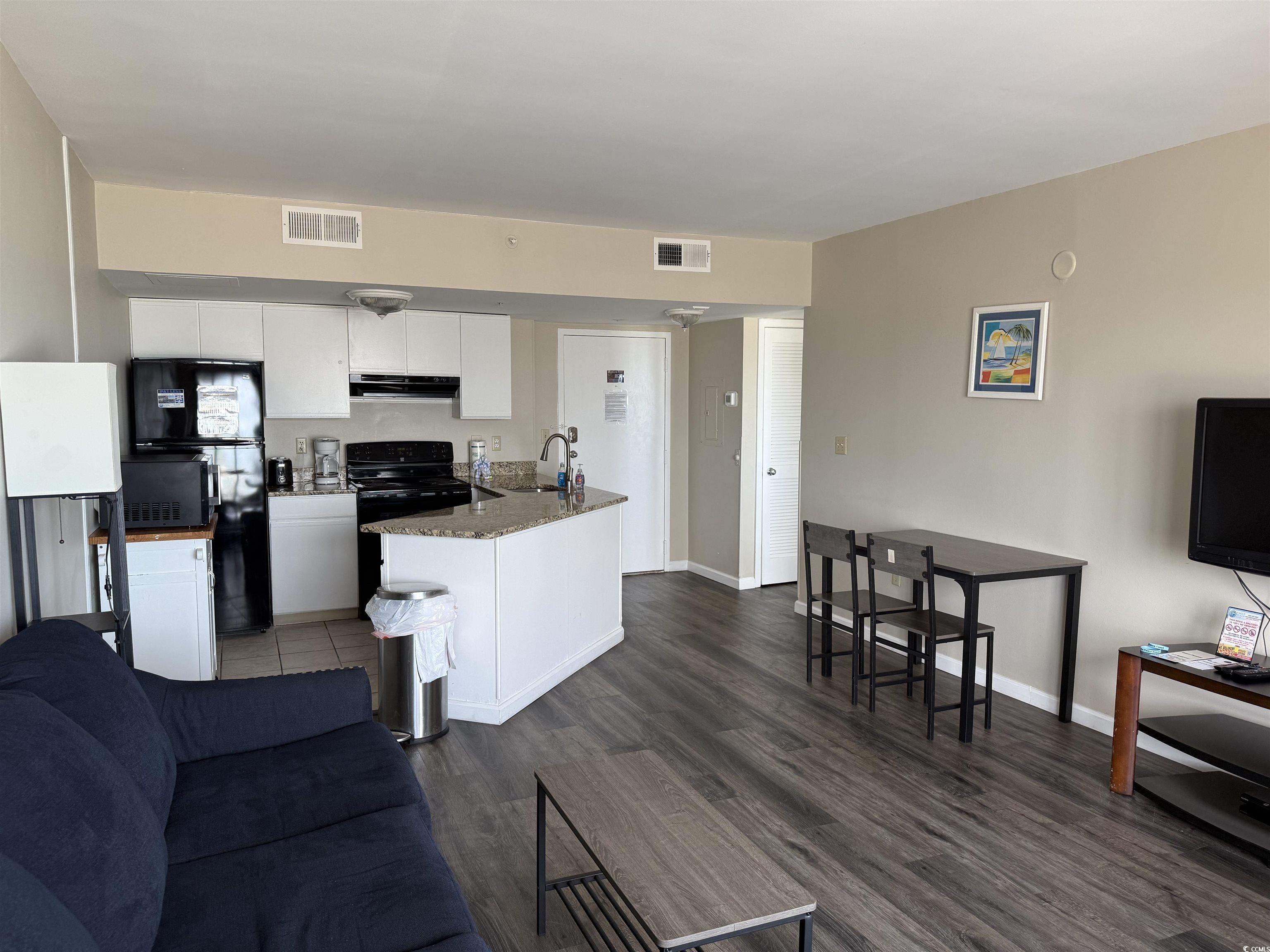 1605 South Ocean Boulevard, Unit 1211 Myrtle Beach, SC 29577 - Photo 11 of 22 Living area with plenty of natural light and dark wood-type flooring