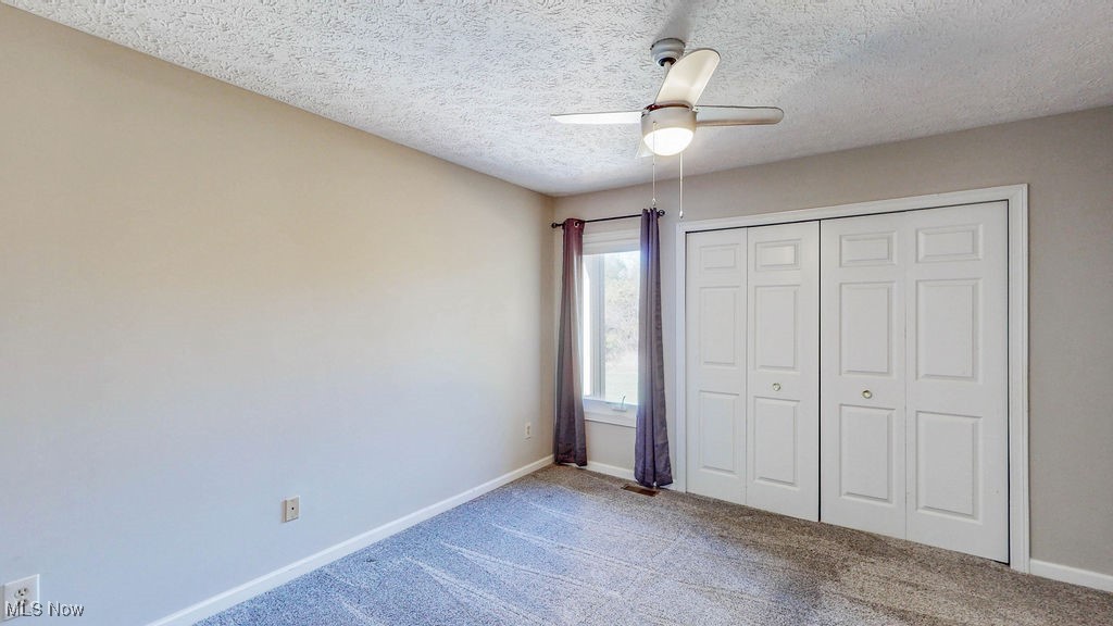 1426 Loop Road, Unit 1426 Kent, OH 44240 - Photo 20 of 40 Guest bedroom with carpet floors, a textured ceiling, a ceiling fan, and a closet.