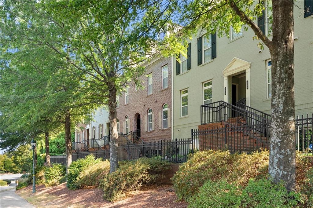 6468 Chariot Street, Unit 19 Atlanta, GA 30328 - Photo 3 of 43 a view of a brick house with a large windows and a tree