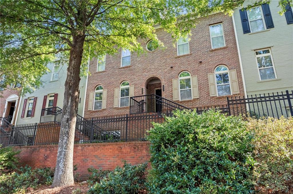 6468 Chariot Street, Unit 19 Atlanta, GA 30328 - Photo 4 of 43 a front view of a house with a garden