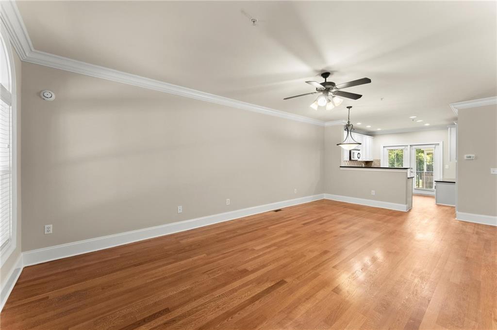 6468 Chariot Street, Unit 19 Atlanta, GA 30328 - Photo 7 of 43 a view of an empty room with a chandelier fan and wooden floor