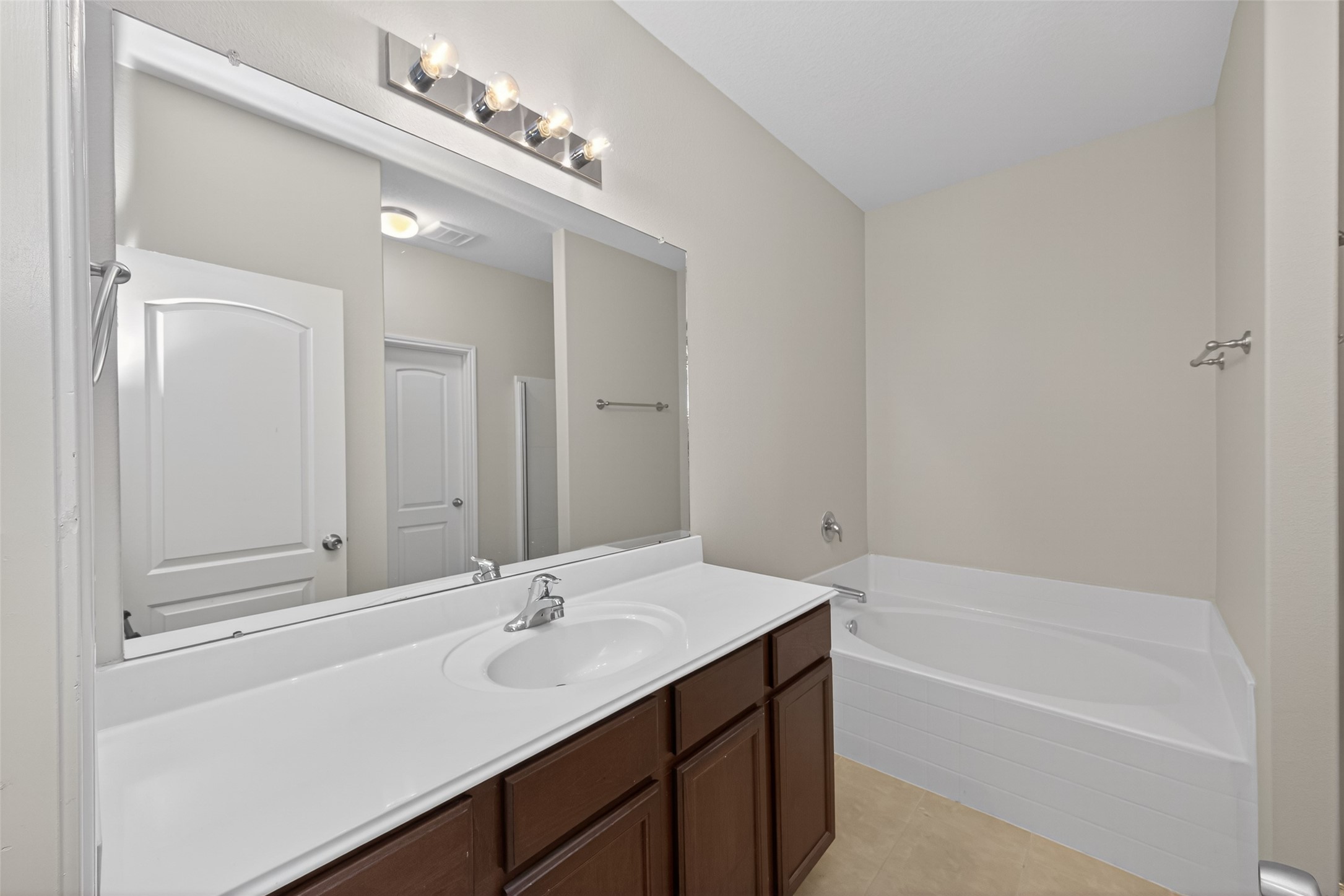 12038 Powderhorn Lane Pinehurst, TX 77362 - Photo 26 of 50 a bathroom with a tub a sink and mirror