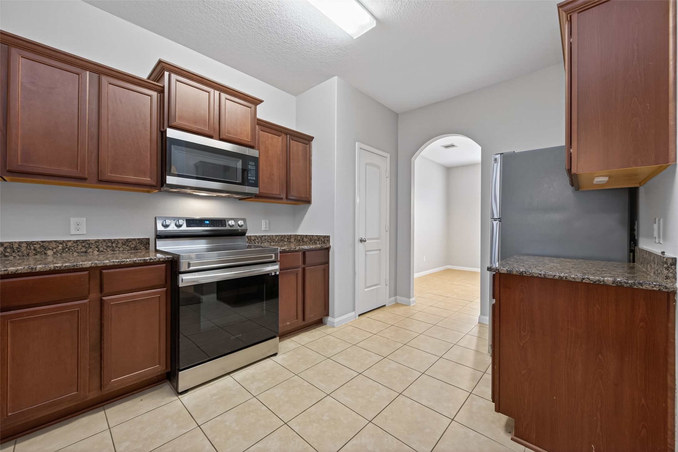 12038 Powderhorn Lane Pinehurst, TX 77362 - Photo 6 of 50 a kitchen with stainless steel appliances granite countertop a stove a sink and a microwave