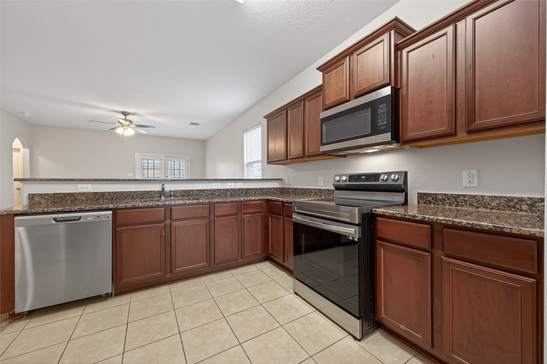 12038 Powderhorn Lane Pinehurst, TX 77362 - Photo 8 of 50 a kitchen with stainless steel appliances granite countertop a stove top oven a sink dishwasher and a microwave oven on the blue kitchen countertops