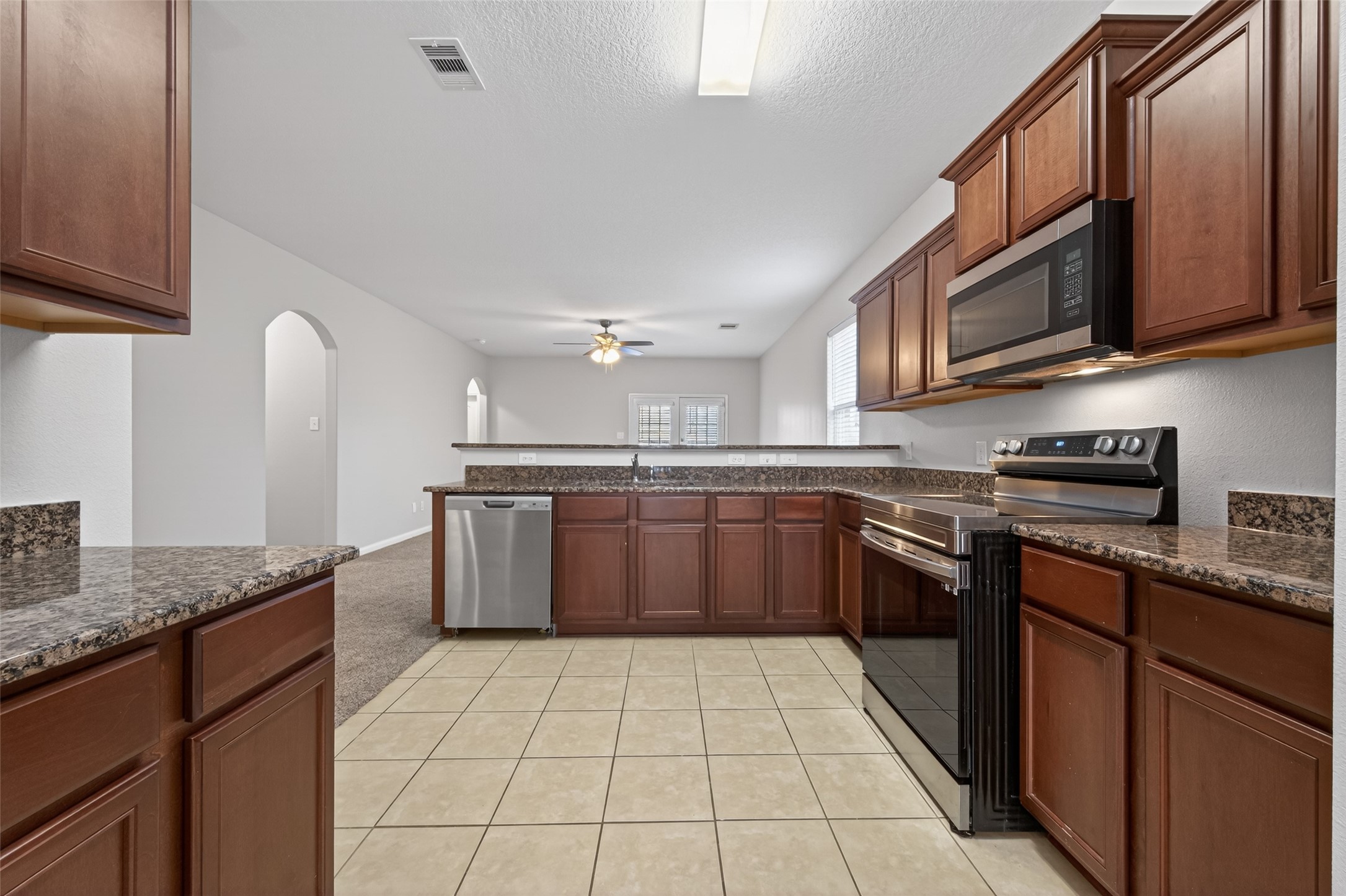 12038 Powderhorn Lane Pinehurst, TX 77362 - Photo 9 of 50 a large kitchen with stainless steel appliances granite countertop a stove a sink dishwasher and a refrigerator