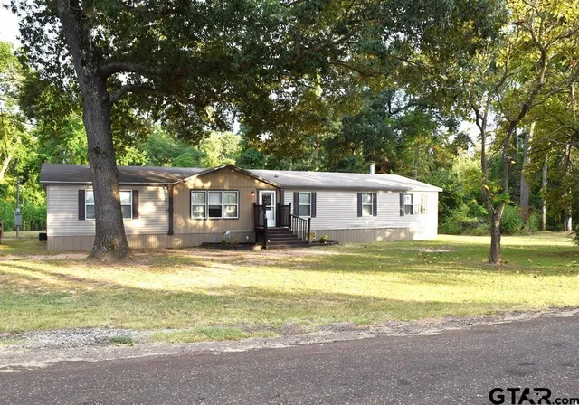 a front view of a house with swimming pool and a yard