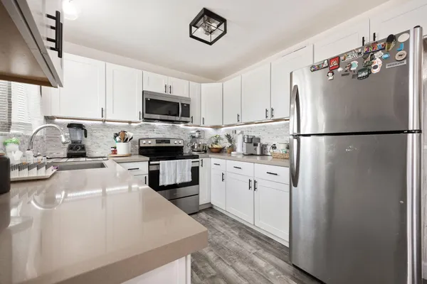 a kitchen with a refrigerator a stove a microwave and cabinets