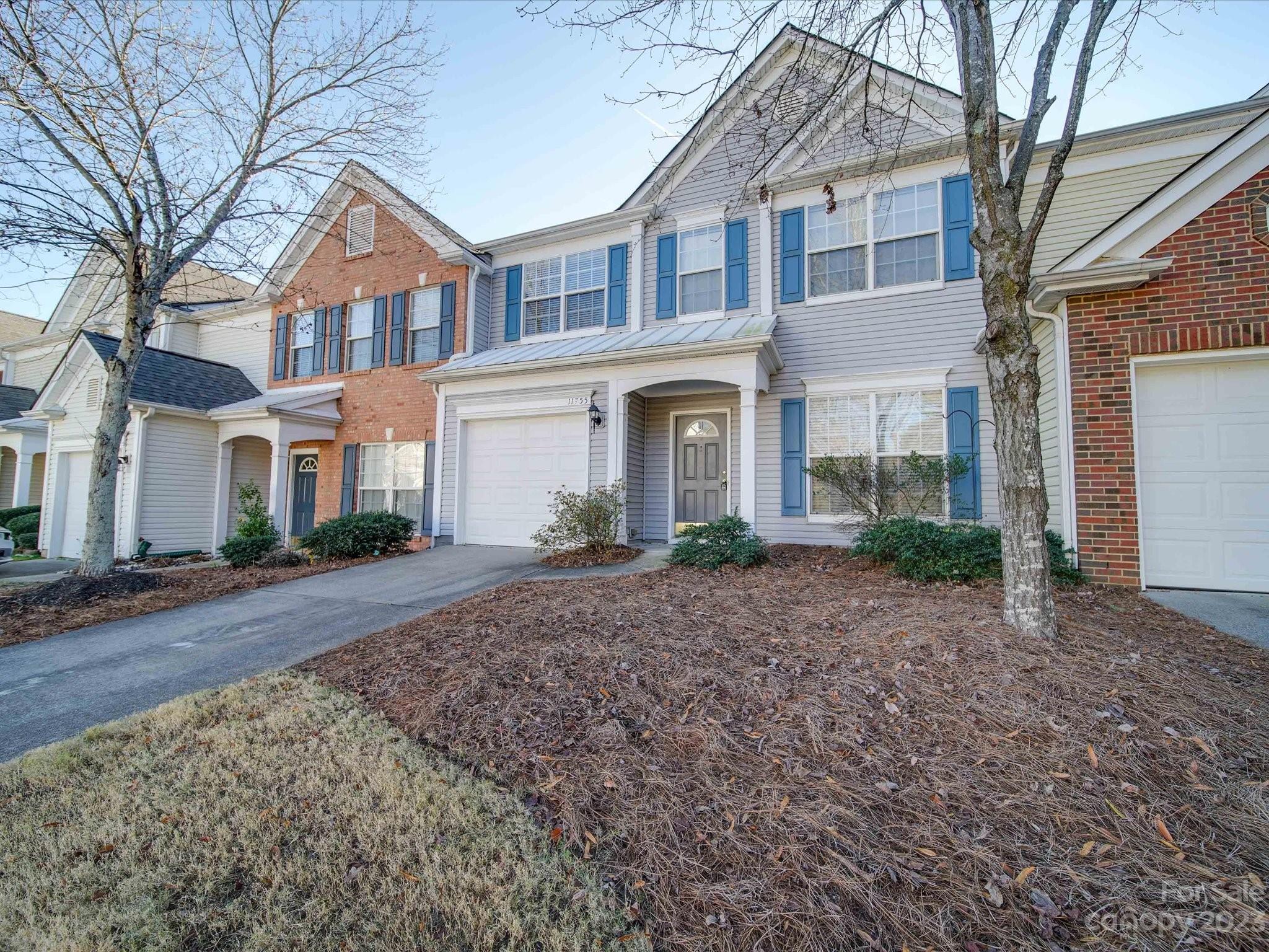 11755 Huxley Road Charlotte, NC 28277 - Photo 2 of 37 a front view of a house with a dirt road and a large tree