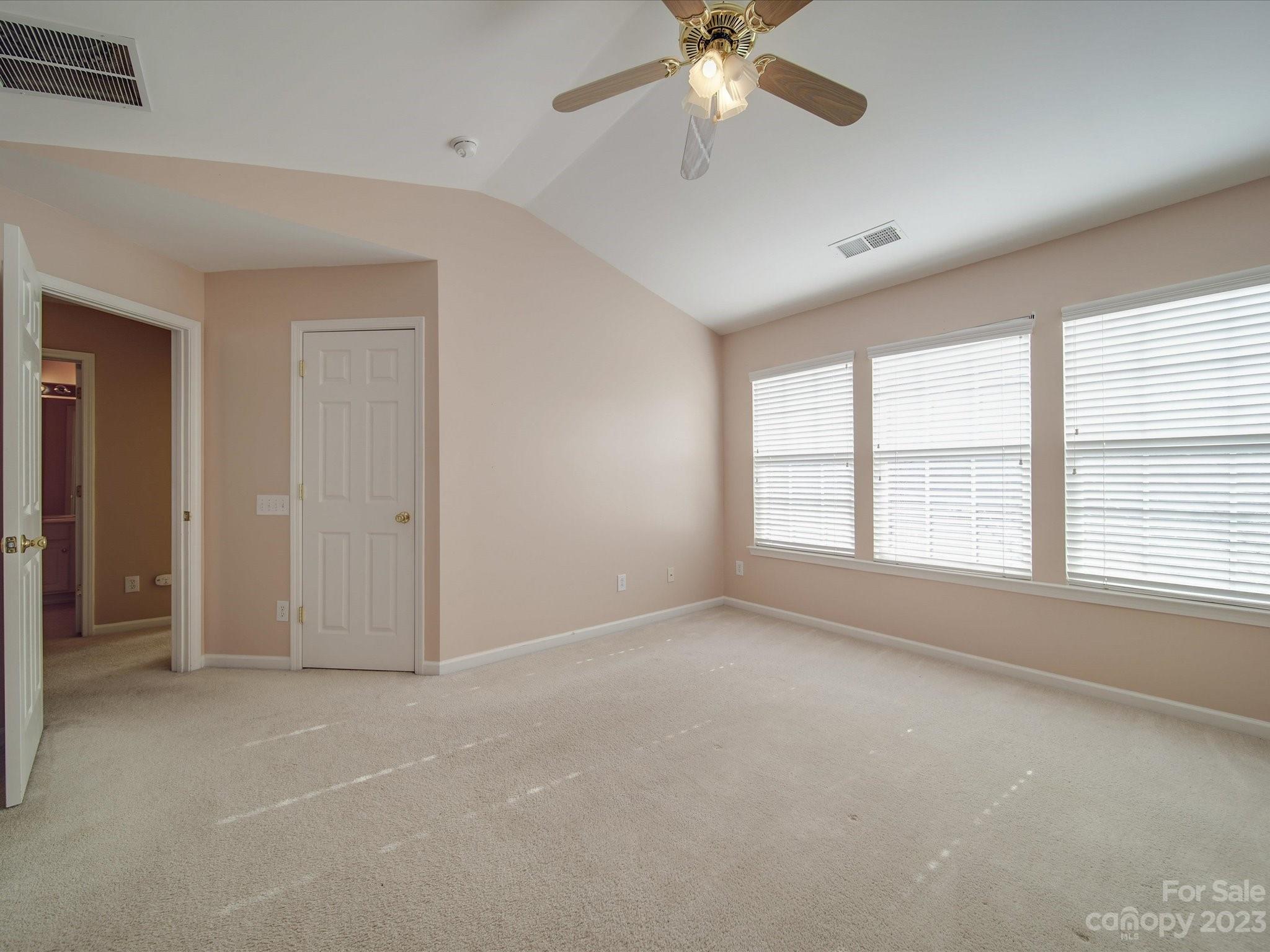 11755 Huxley Road Charlotte, NC 28277 - Photo 22 of 37 an empty room with chandelier fan and windows