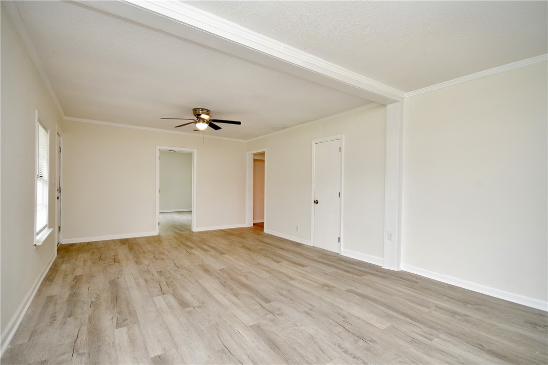 115 Stancil Road Anderson, SC 29625 - Photo 12 of 35 A spacious, airy living room featuring elegant crown molding and resilient plank flooring.