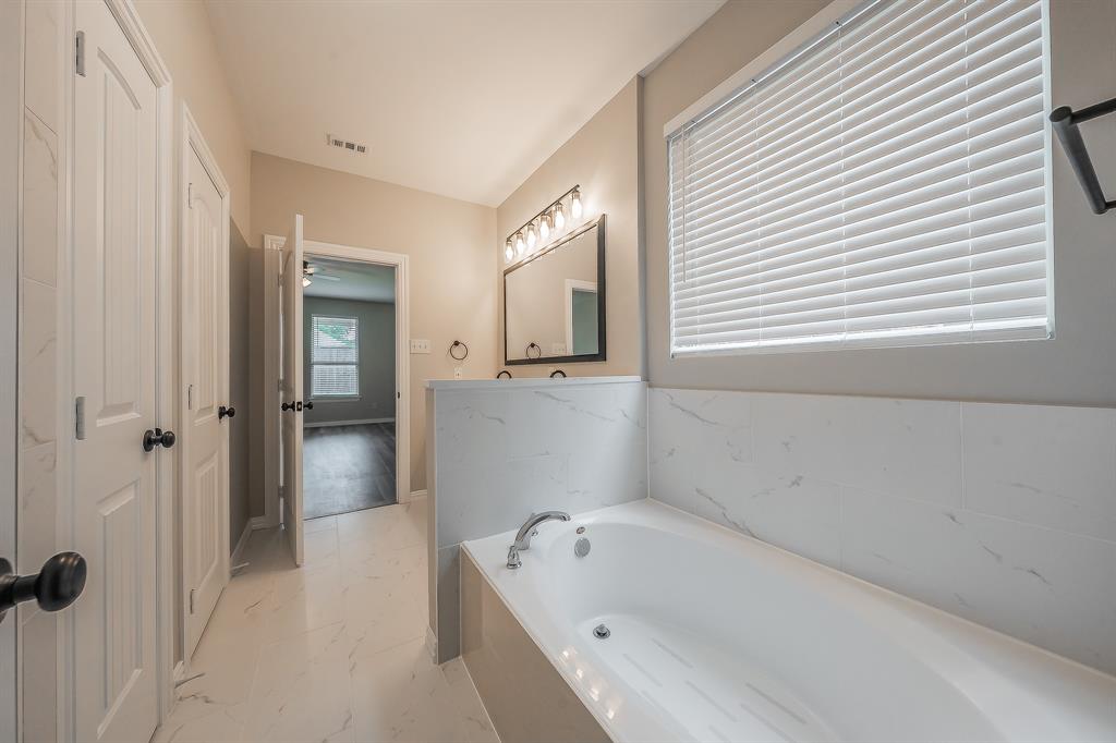 412 Hideaway Road McKinney, TX 75072 - Photo 22 of 40 a bathroom with a bathtub and shower