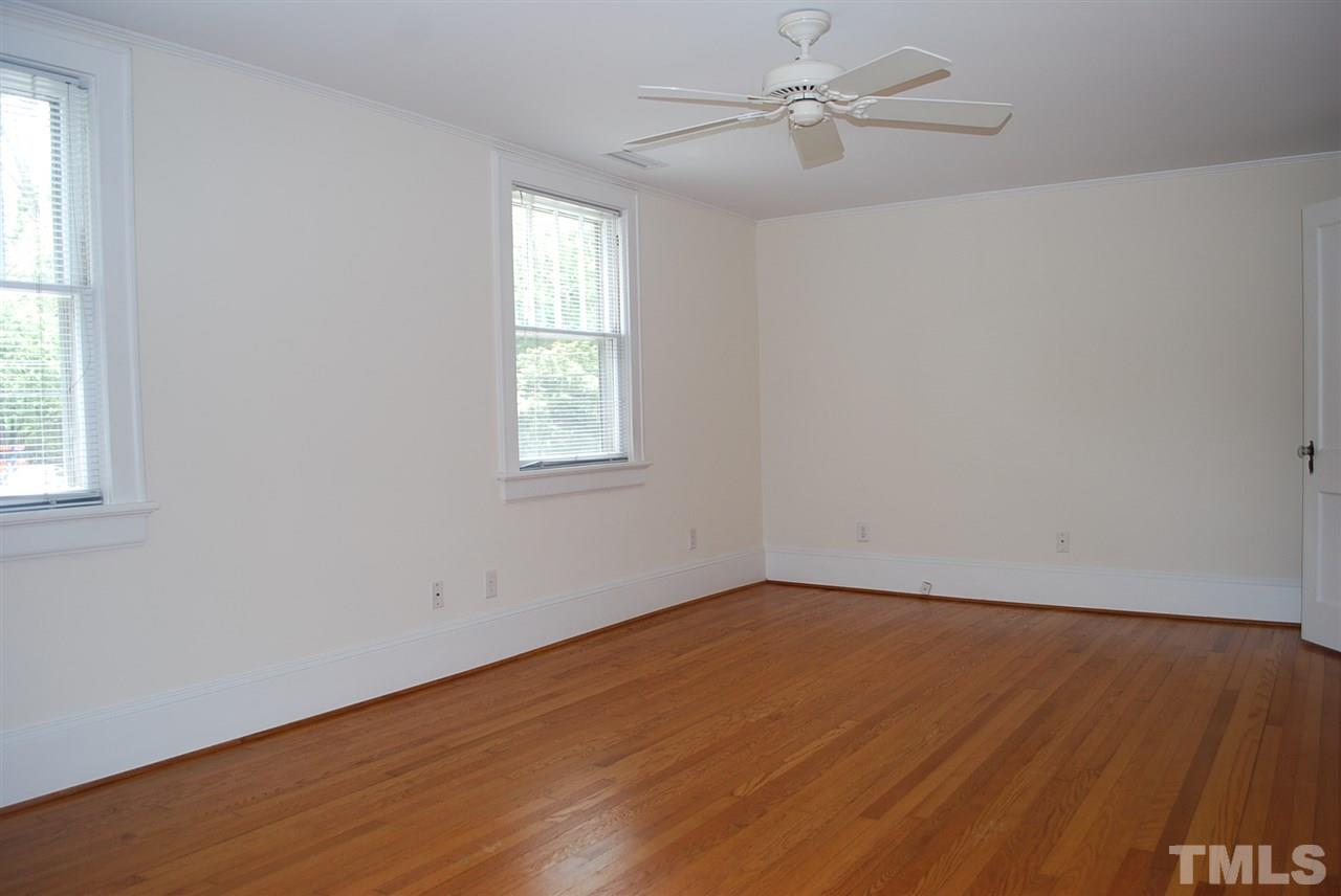 2274 The Circle Raleigh, NC 27608 - Photo 18 of 25 an empty room with wooden floor ceiling fan and windows
