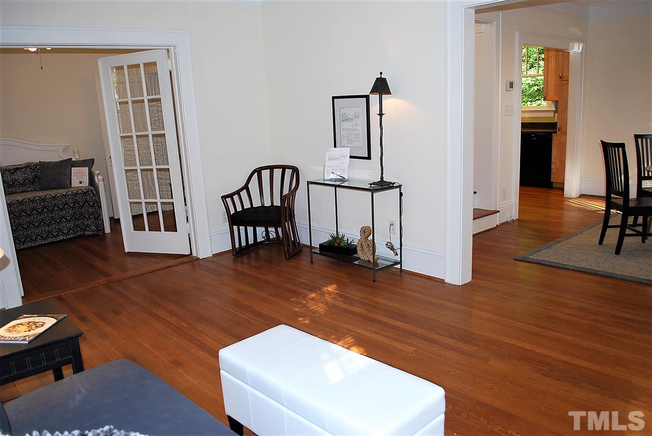 2274 The Circle Raleigh, NC 27608 - Photo 4 of 25 a living room with furniture a flat screen tv and a wooden floor