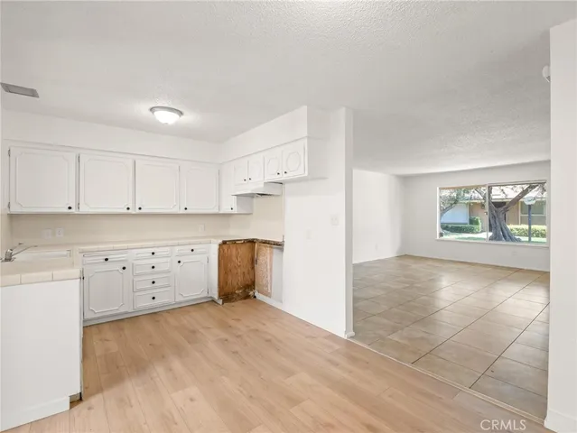 a kitchen with white cabinets and sink