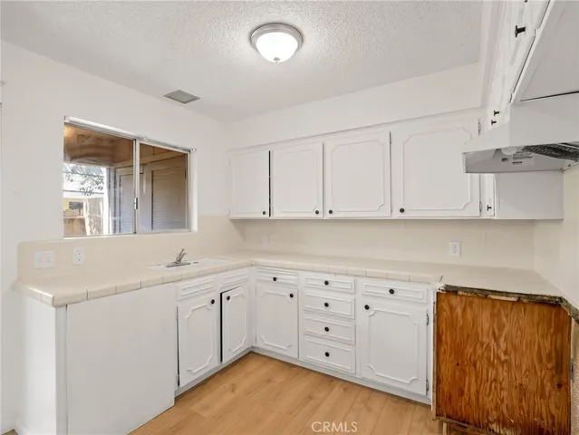 a kitchen with granite countertop white cabinets and white appliances