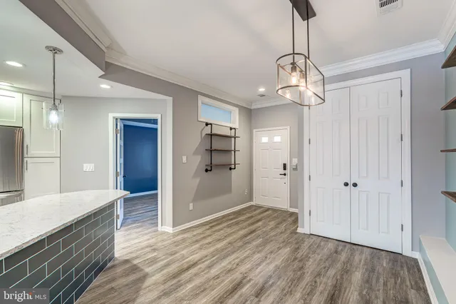 a view of a hallway with wooden floor and chandelier