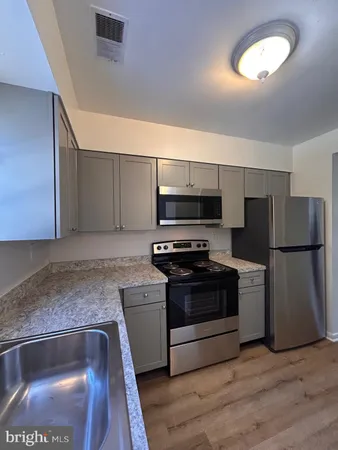 a kitchen with stainless steel appliances granite countertop a sink and a refrigerator