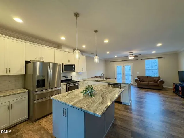 a kitchen with kitchen island a counter top space appliances and a center island