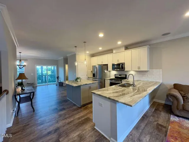 a kitchen with stainless steel appliances kitchen island granite countertop a sink and cabinets