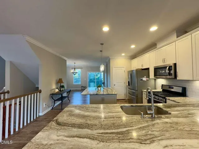 a kitchen with stainless steel appliances granite countertop a sink stove and refrigerator