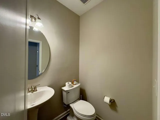 a view of a hallway with a door and wooden floor
