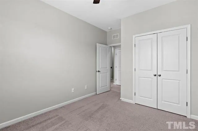 an empty room with a window and a ceiling fan