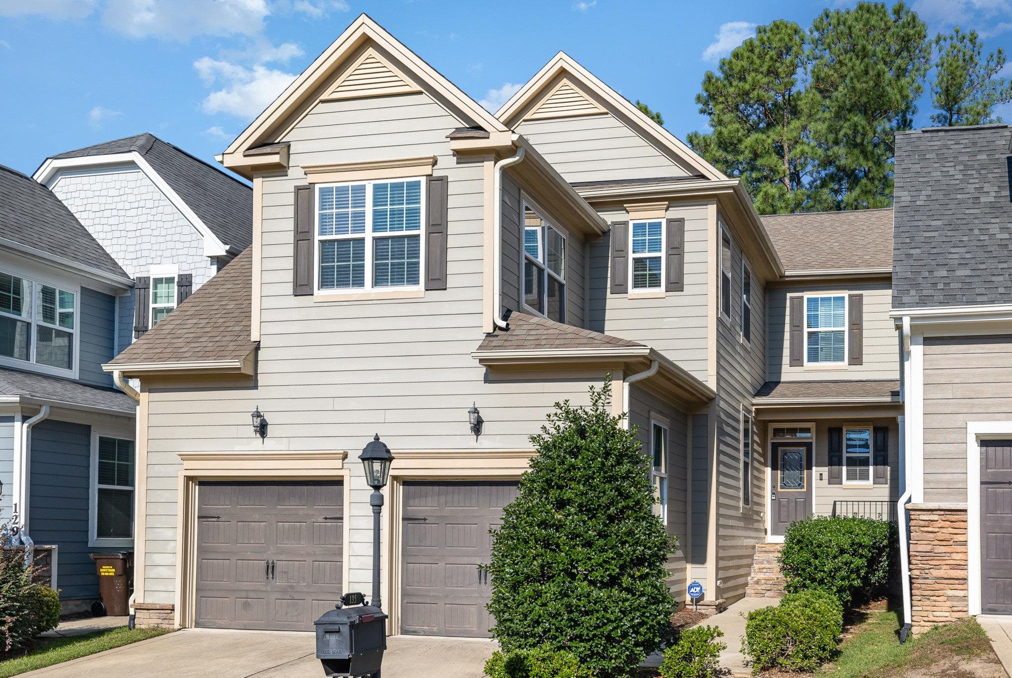 a view of a white house next to a yard