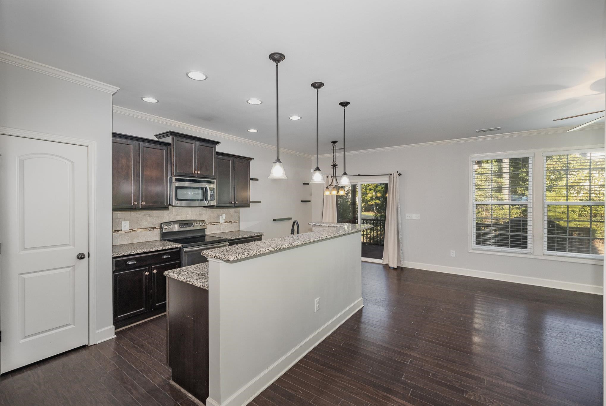 135 Pine Hawk Drive Spring Lake, NC 28390 - Photo 8 of 41 a kitchen with stainless steel appliances a stove top oven a sink a refrigerator a center island and a window