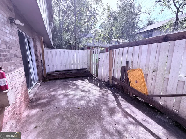 a view of a backyard with swing and wooden fence