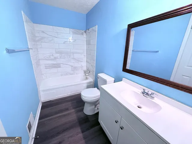 a bathroom with a sink a toilet and a mirror