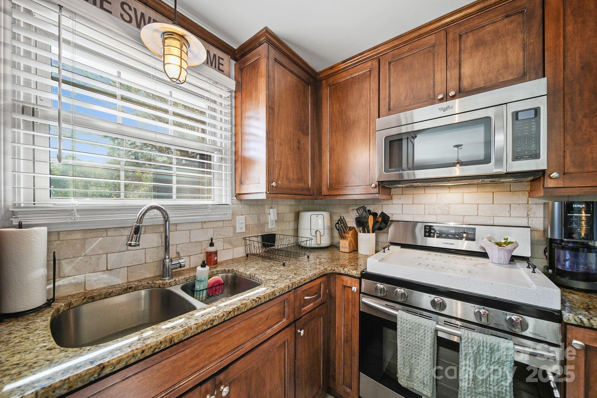 9116 Brief Road Mint Hill, NC 28227 - Photo 7 of 24 a kitchen with granite countertop a sink a stove and cabinets