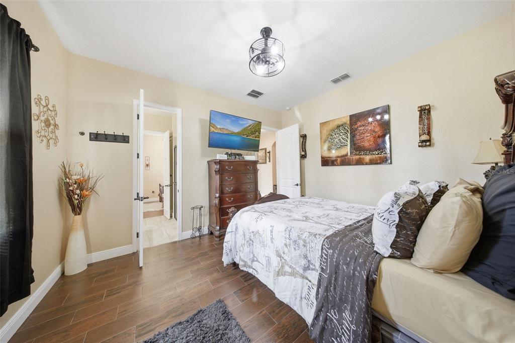13429 Montevista Road Clermont, FL 34711 - Photo 48 of 89 a spacious bedroom with a bed and wooden floor